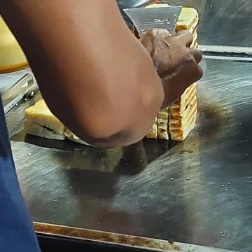 Bread that is being baked and smeared with cheese and chocolate Stock Photos