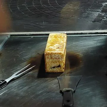 Bread that is being baked and smeared with cheese and chocolate Stock Photos