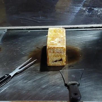 Bread that is being baked and smeared with cheese and chocolate Stock Photos