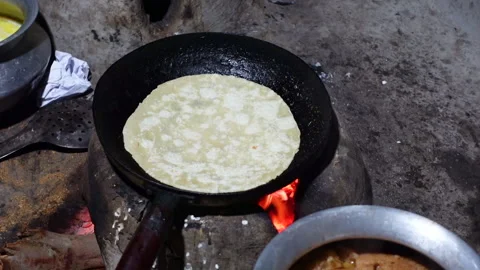 Bread being baked in a fry-pan in a clay oven. Stock Footage 341698844
