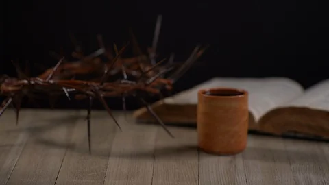 Bread being ripped into quarters with Cup, Crown of Thorns and Bible 스톡 동영상 128587331