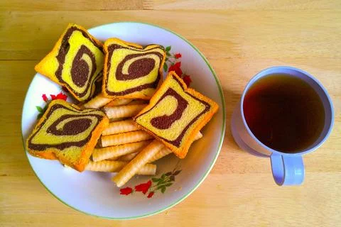 Bread biscuits and also rolled biscuits in a bowl and also tea on the table 스톡 사진