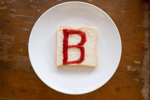 Bread of breakfast is written B by ketchup on write plate. A to Z and Number  Stock Photos