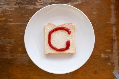 Bread of breakfast is written C by ketchup on write plate. A to Z and Number Stock Photos