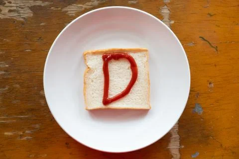 Bread of breakfast is written D by ketchup on write plate. A to Z and Number  Stock Photos