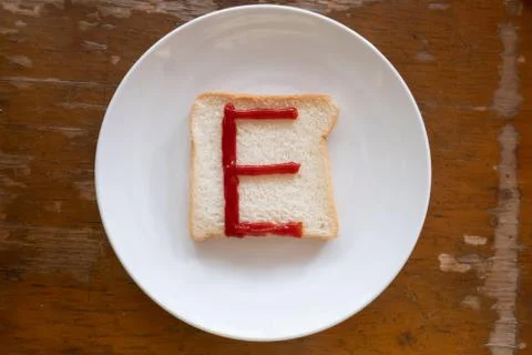 Bread of breakfast is written E by ketchup on write plate. A to Z and Number  Stock Photos