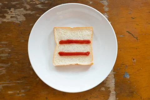 Bread of breakfast is written Equal sign by ketchup on write plate. A to Z an Stock Photos