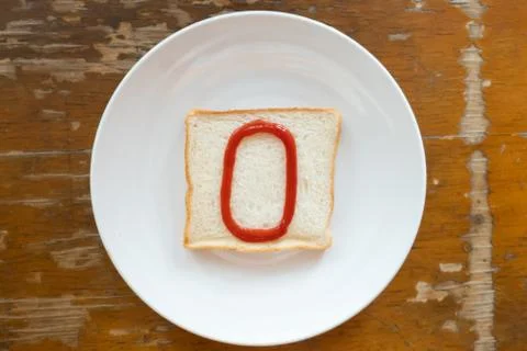 Bread of breakfast is written number 0 by ketchup on write plate. A to Z and  Stock Photos