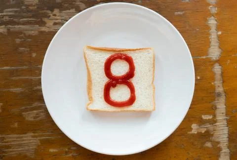 Bread of breakfast is written number 8 by ketchup on write plate. A to Z and  Stock Photos