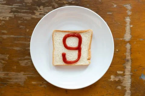 Bread of breakfast is written number 9 by ketchup on write plate. A to Z and  Stock Photos