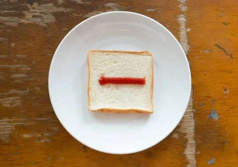 Bread of breakfast is written Question mark sign by ketchup on write plate. A Stock Photos