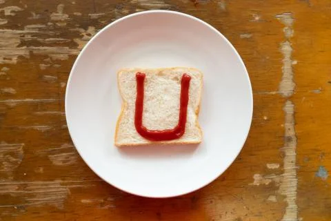 Bread of breakfast is written U by ketchup on write plate. A to Z and Number  Stock Photos