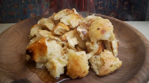 The bread, broken into pieces, is covered with butter on a wooden plate. Stock Footage 144523480