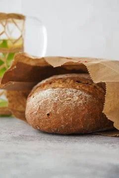 Bread in a brown bag on a gray surface Stock Photos