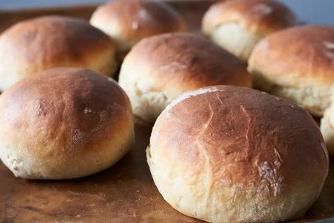 Bread buns on a baking sheet. Selective focus. Stock Photos