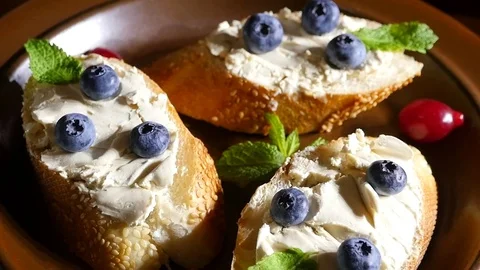 Bread with butter and blueberries on a plate Stock Footage