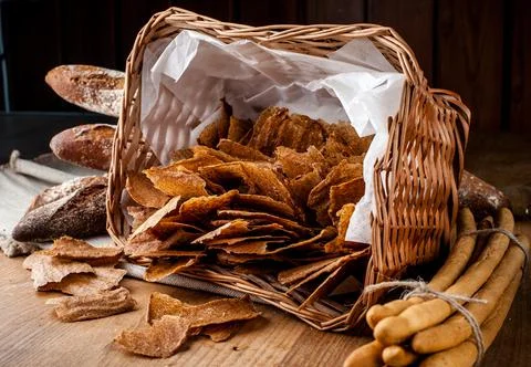 Bread chips. Basket with chips. Scattered crispy pastries. Chips in a wooden Stock Photos