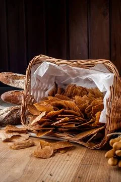 Bread chips. Basket with chips. Scattered crispy pastries. Chips in a wooden Stock Photos