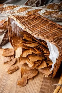 Bread chips. Basket with chips. Scattered crispy pastries. Chips in a wooden Stock Photos