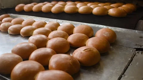 Bread comes out of the oven in close-up on a conveyor belt and is sprayed with Stock-Footage 139162332