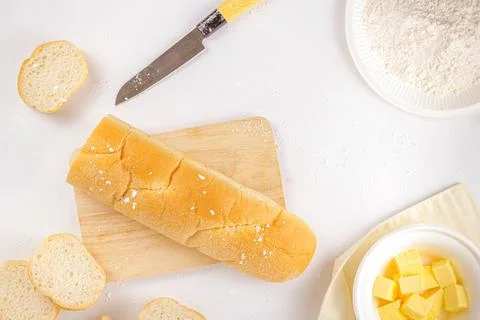 Bread concept a loaf of bread, a few slices of bread, a knife, a wooden cutti Stock Photos