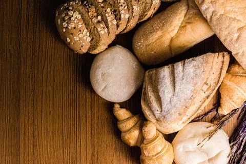 Bread concept several slices of dark brown bread with seeds, buns, croissants Stock Photos