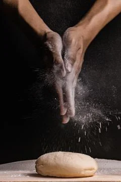 Bread concept two hands rubbing flour onto a few bun doughs on the wooden tab Stock Photos