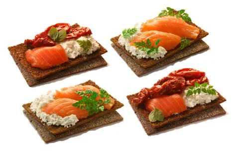 Bread crisps with salmon, soft cheese, dried tomatoes and chervil Stock Photos