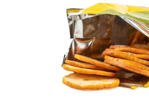 Bread crisps spilling from an opened snack package onto white background. Stock Photos