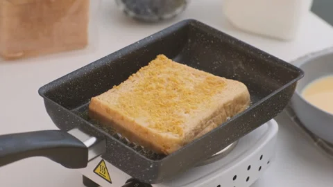 Bread croutons in an egg are fried in a pan. Close-up. Fried bread slices Stock Footage 242565501