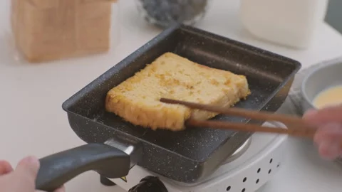 Bread croutons in an egg are fried in a pan. Close-up. Fried bread slices Stock Footage 242565578