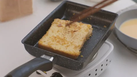 Bread croutons in an egg are fried in a pan. Close-up. Fried bread slices Stock Footage 242565643