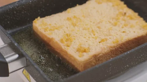 Bread croutons in an egg are fried in a pan. Close-up. Fried bread slices Stock Footage 242565715