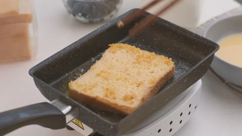 Bread croutons in an egg are fried in a pan. Close-up. Fried bread slices Stock Footage 242565784