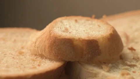 Bread crumbs falling on slices of white bread in slow motion on spinning plat Vídeos de archivo 164760626