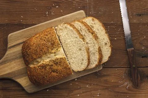 Bread on a cutting board and a knife. Stock Photos