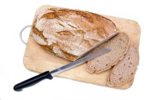 Bread on cutting board with a knife on white background from above Stock Photos