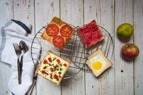Bread with different ingredients on grills on a background with fruits Stock Photos