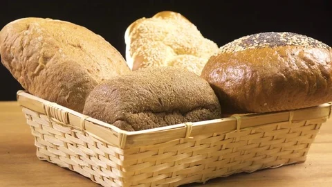 Bread of different kinds lies in the basket and spins on the table Stock Footage 75874976