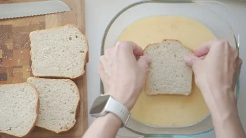 Bread dipped in egg mixture in glass dish, with more slices nearby Stock Footage 337483684