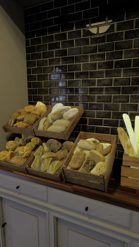 Bread display in a cozy bakery showcasing various baked goods and decor Stock Footage 314255758