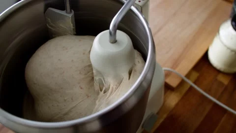 Bread dough being kneaded in robust home stand mixer; slow camera push in. Stock Footage 343629064