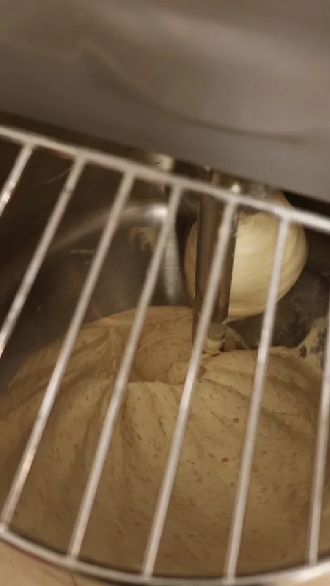 Bread dough being mixed in industrial mixer, kneading process in bakery kitchen Stock Footage 333245481