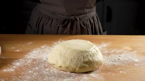 Bread dough falling ona natural wooden work surface in slow motion 4K Stock Footage 266220618