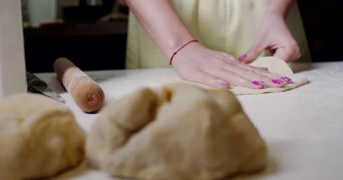 Bread dough is prepared on the kitchen table pressed with flour. Slow motion. Stock Footage 146705116