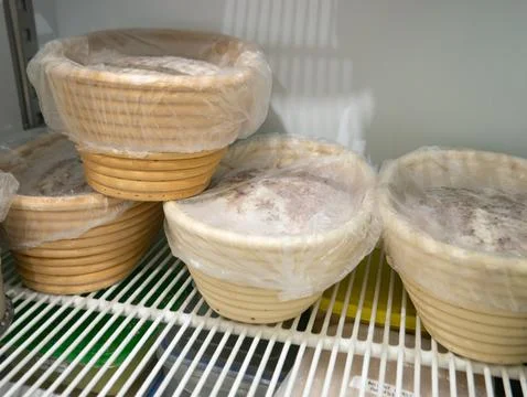Bread Dough Proofing in Banneton Baskets Inside Refrigerator, Bakery Fermen.. 스톡 사진