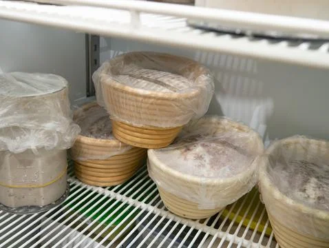 Bread Dough Proofing in Banneton Baskets Inside Refrigerator, Bakery Fermen.. 스톡 사진