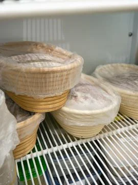 Bread Dough Proofing in Banneton Baskets Inside Refrigerator, Bakery Fermen.. Stock Photos