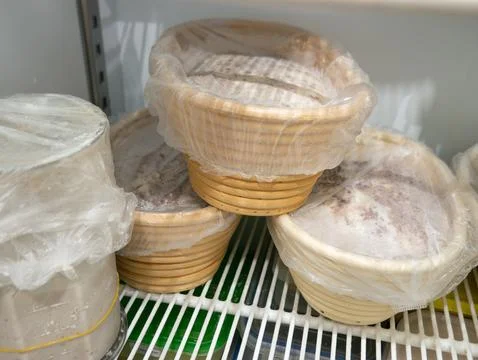 Bread Dough Proofing in Banneton Baskets Inside Refrigerator, Bakery Fermen.. Stock Photos