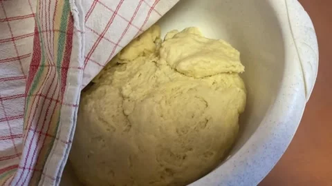 Bread dough rising in white bowl under kitchen towel Stock Footage 317982167